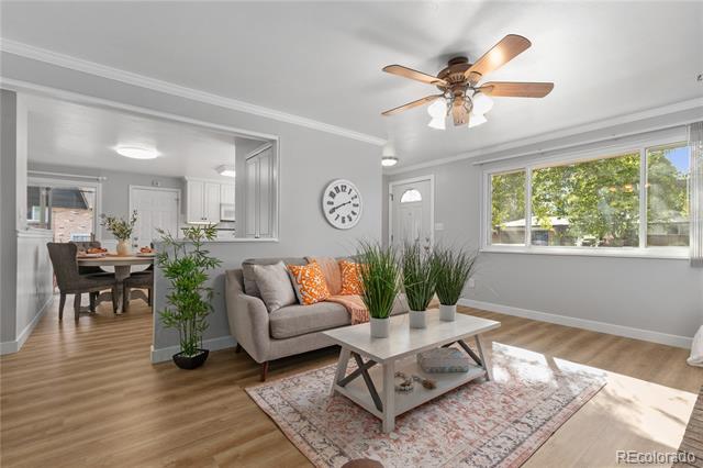 Living room with a gray sofa, orange pillows, and a coffee table beside the dining area.