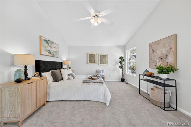 Bedroom with a white bed, black tufted headboard, and light wood dresser.