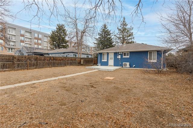 Blue house behind a broad dormant lawn and concrete walkway.