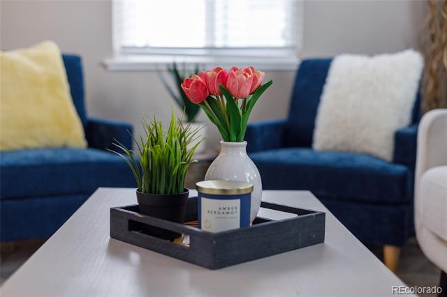 Living room with deep blue sofas and a coffee table styled with pink tulips and greenery.