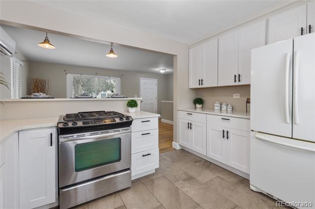 Kitchen with white cabinetry, stainless steel appliances, and a tiled floor.