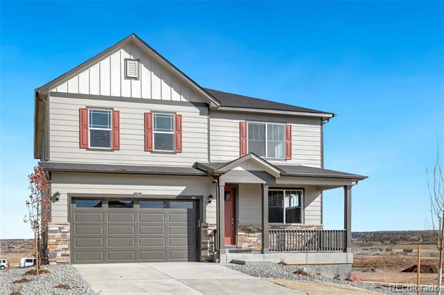 Two-story house with red shutters, stone accents, a two-car garage, and a covered porch.