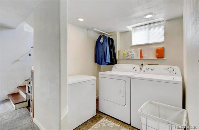 Laundry room with white washer, dryer, and chest freezer beneath a window.