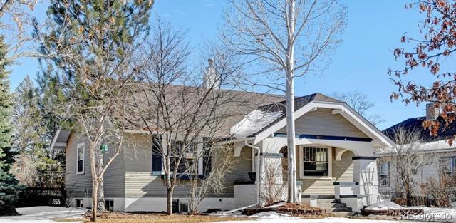 Single-story house with a gabled porch, front steps, leafless trees, and patches of snow.