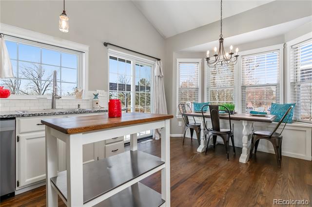 Kitchen with a wood-topped island and dining table beside large windows.