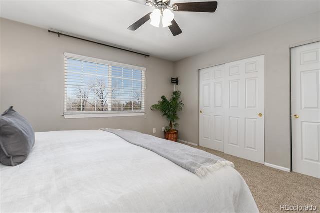Bedroom with a white bed, window blinds, potted plant, and white closet doors.