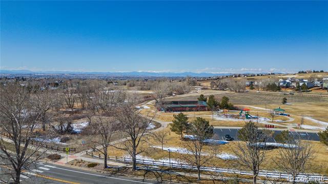 Aerial view of a neighborhood park and open space with distant mountains.