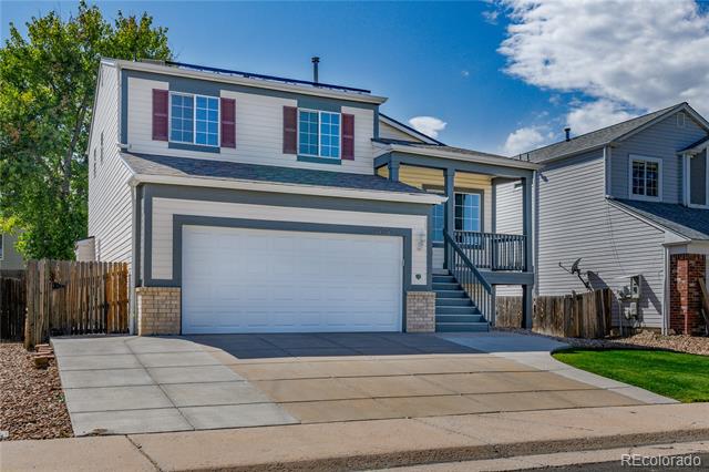 Two-story gray house with a double garage, broad driveway, and steps to the covered entry.