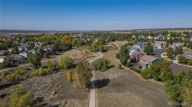 Aerial view of a neighborhood green space with a winding walking path and homes.