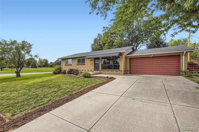 Single-story brick house with a red garage door and wide concrete driveway.