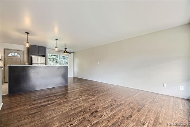 Open living area with hardwood floors and a dark kitchen island.