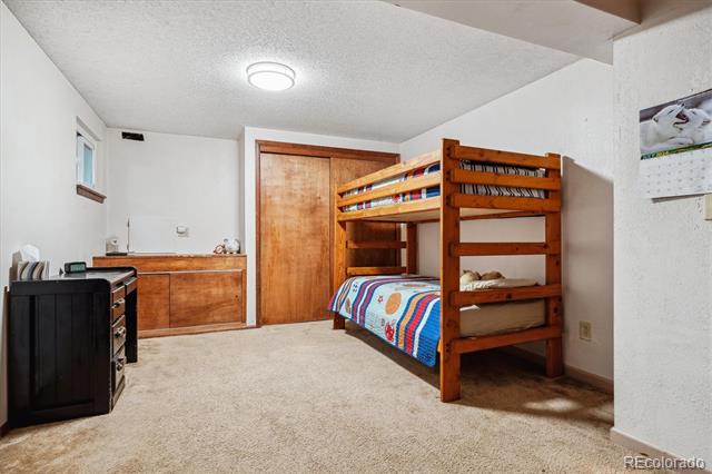 Bedroom with a wooden bunk bed, colorful bedding, and built-in cabinetry.