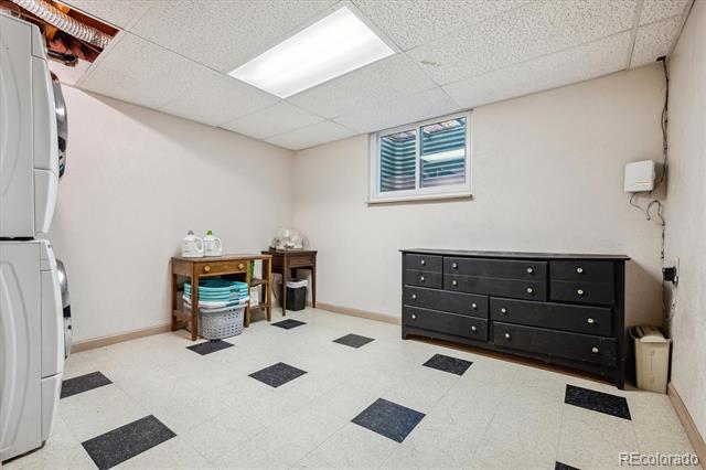 Laundry room with washer and dryer, storage table, and long black dresser.