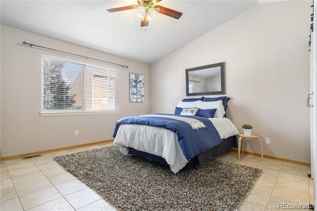 Bedroom with navy and white bedding, a textured rug, and a window with blinds.