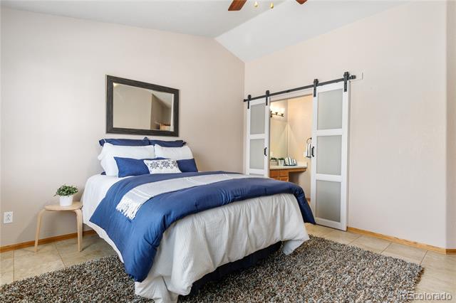 Bedroom with navy and white bedding, a framed mirror, and sliding barn doors to the bathroom.