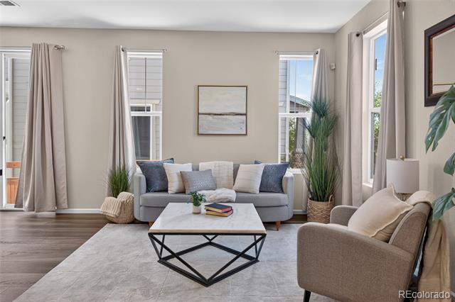 Staged living room with a gray sofa, beige armchair, and geometric coffee table.