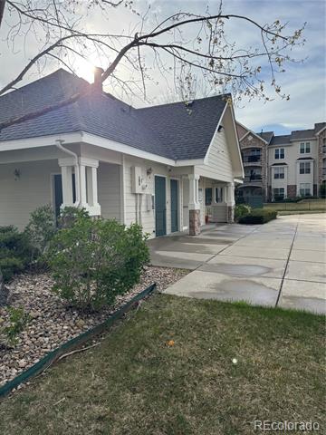 Residential building exterior with a covered entrance and neighboring apartment buildings.