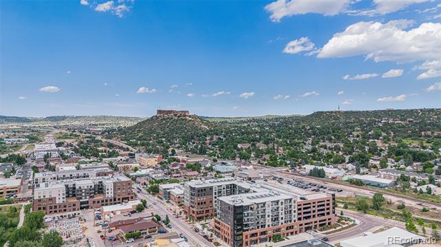 Aerial view of Denver apartments with tree-covered hills in the distance.