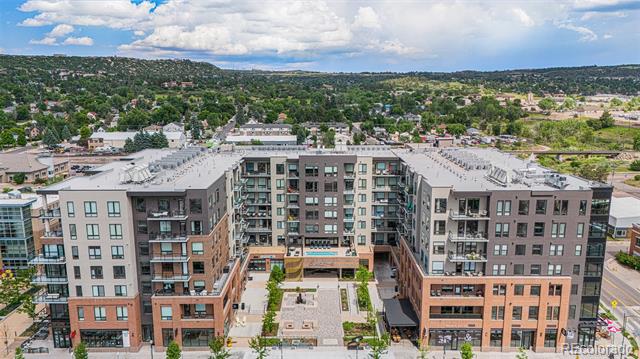 Aerial view of an apartment building with balconies and a landscaped courtyard.