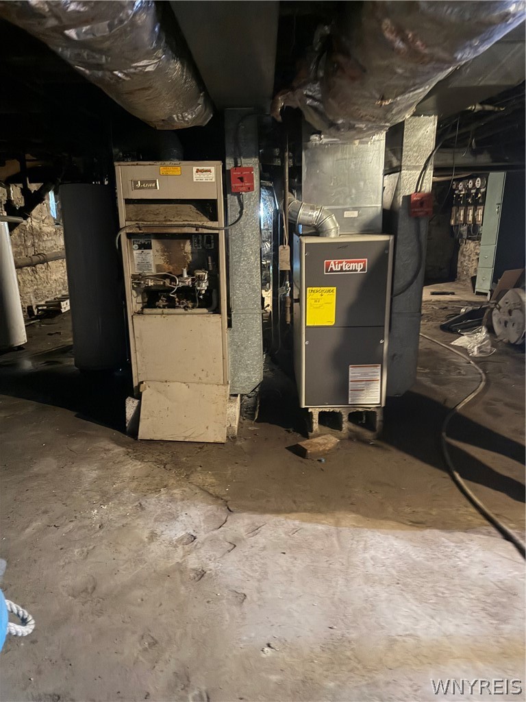 Basement mechanical room with two furnaces and exposed ductwork.