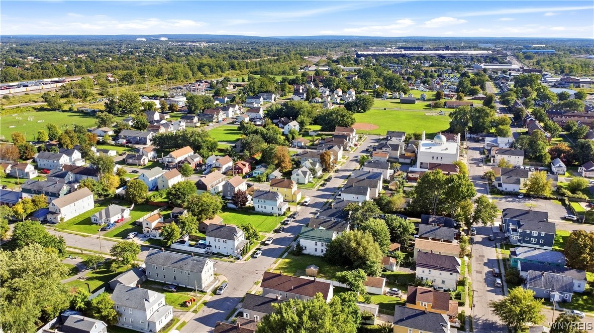 Aerial view of a residential neighborhood with tree-lined streets and a nearby green park.