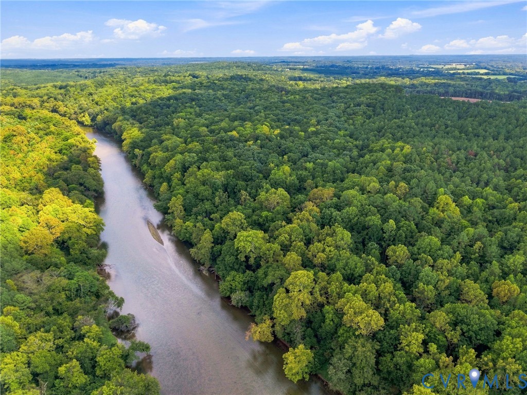 Aerial view of a winding river through dense green woodland.
