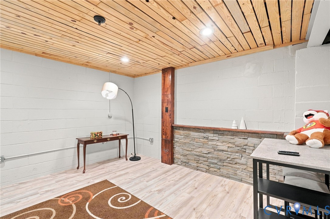 Finished room with a wood-plank ceiling and stone-faced counter.