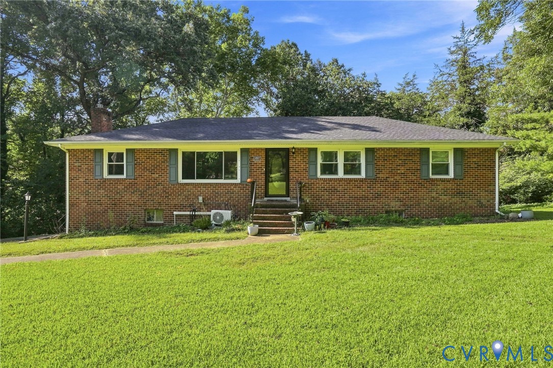 Single-story brick ranch house with pale green shutters, front steps, and a broad lawn.