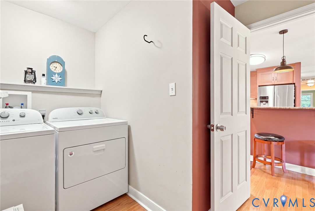 Laundry room with a white washer and dryer beside an open doorway to the kitchen.