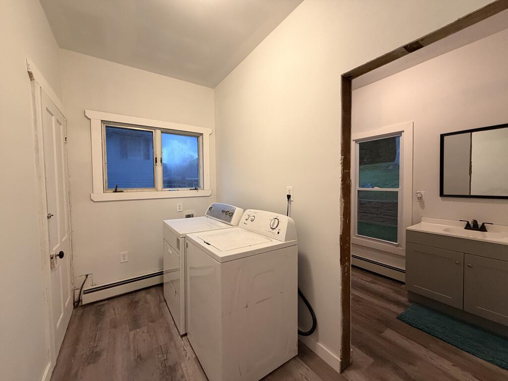 Laundry room with washer and dryer beside an open doorway to a bathroom.