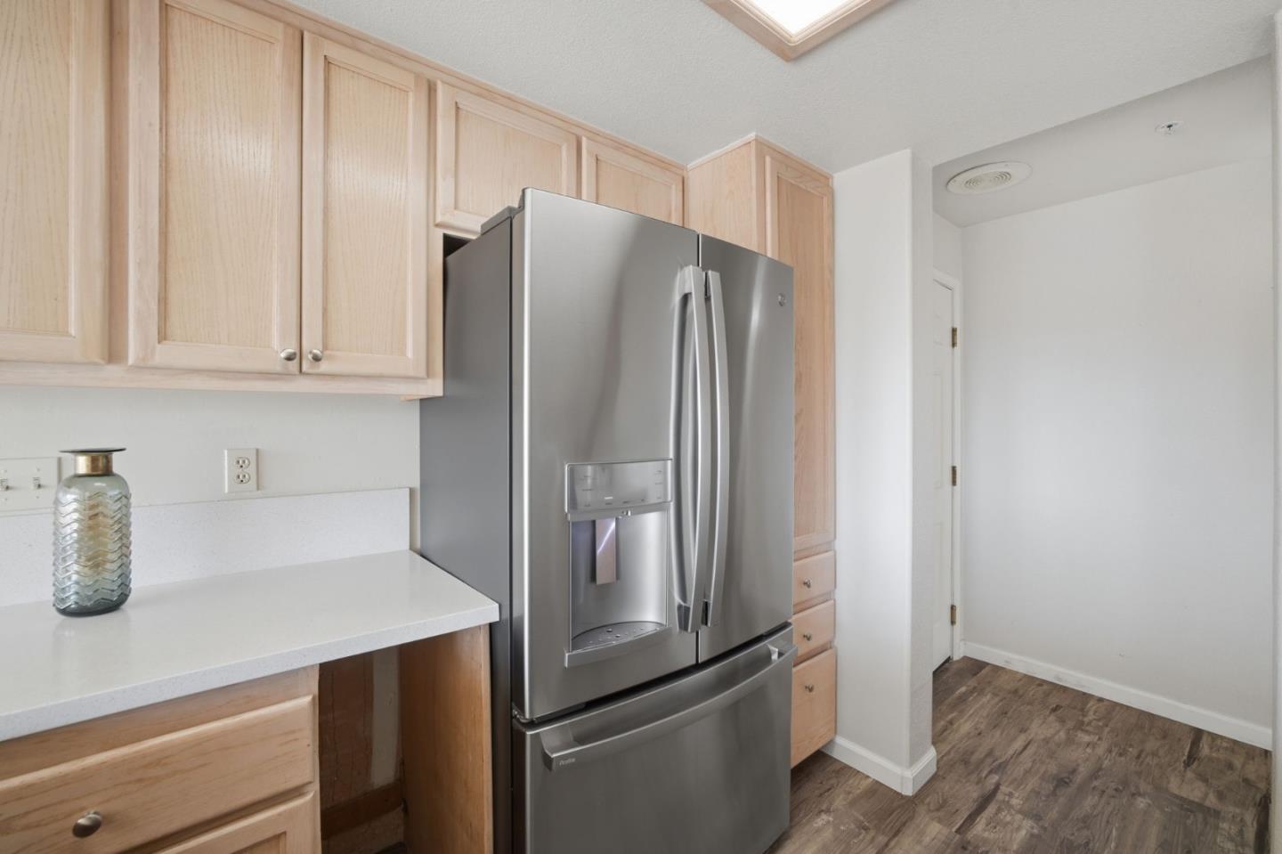 Kitchen with light wood cabinets, white countertops, and a stainless steel French-door refrigerator.