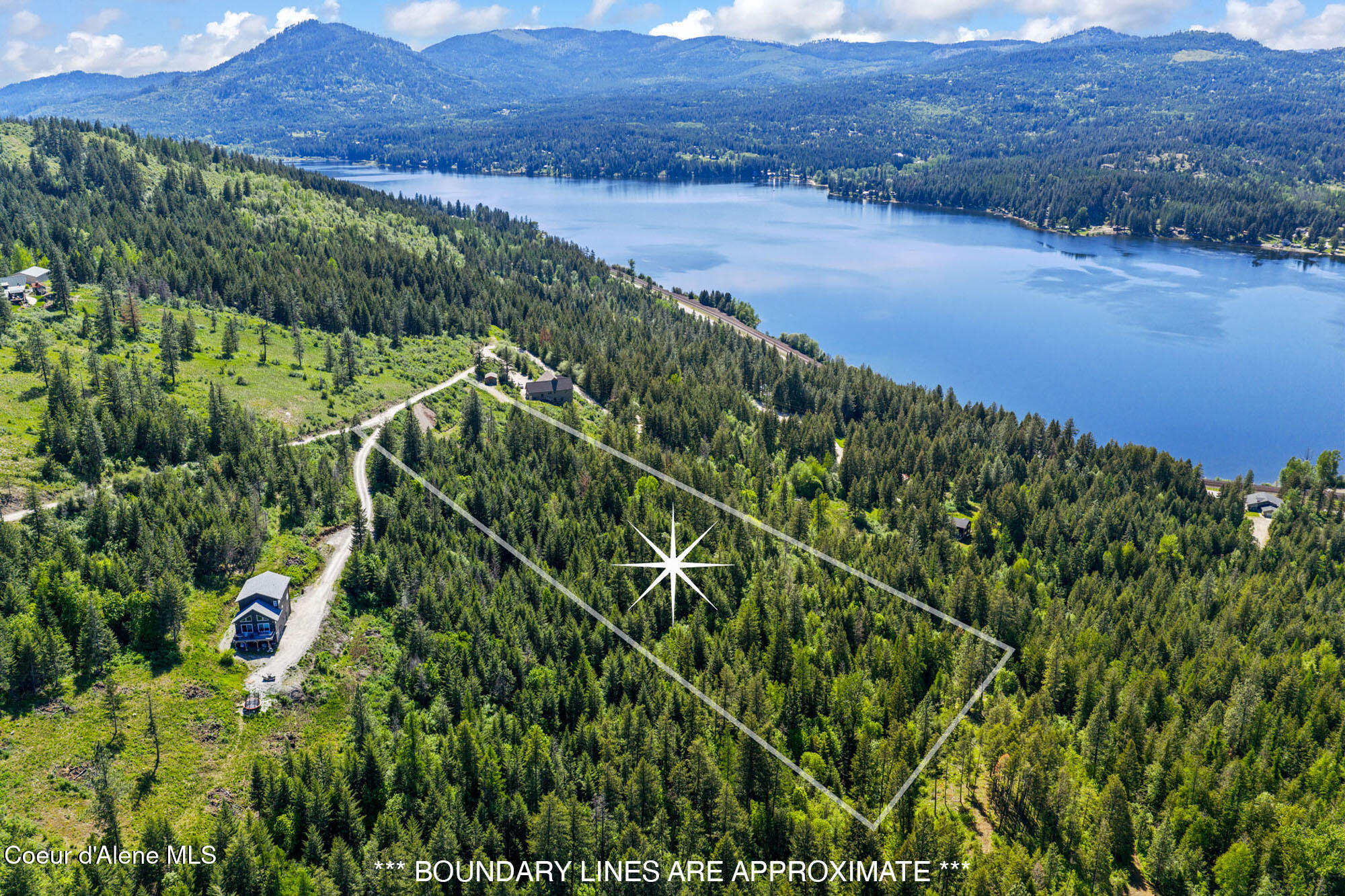 Wooded parcel outlined above a lake, with forested mountains in the distance.