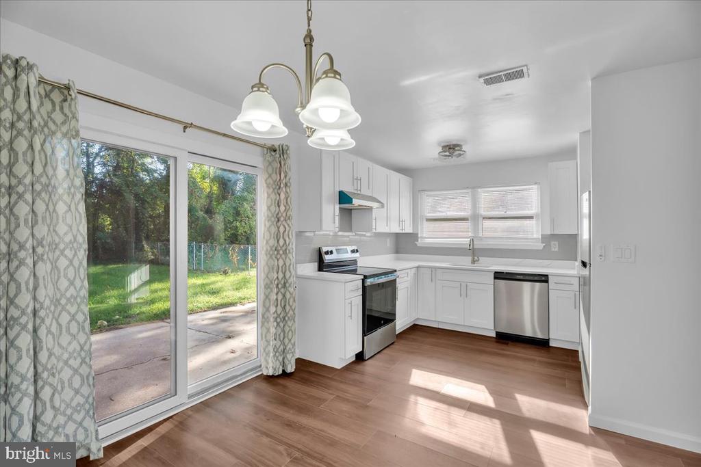 Kitchen with white cabinets, stainless steel appliances, and sliding glass doors to a patio.