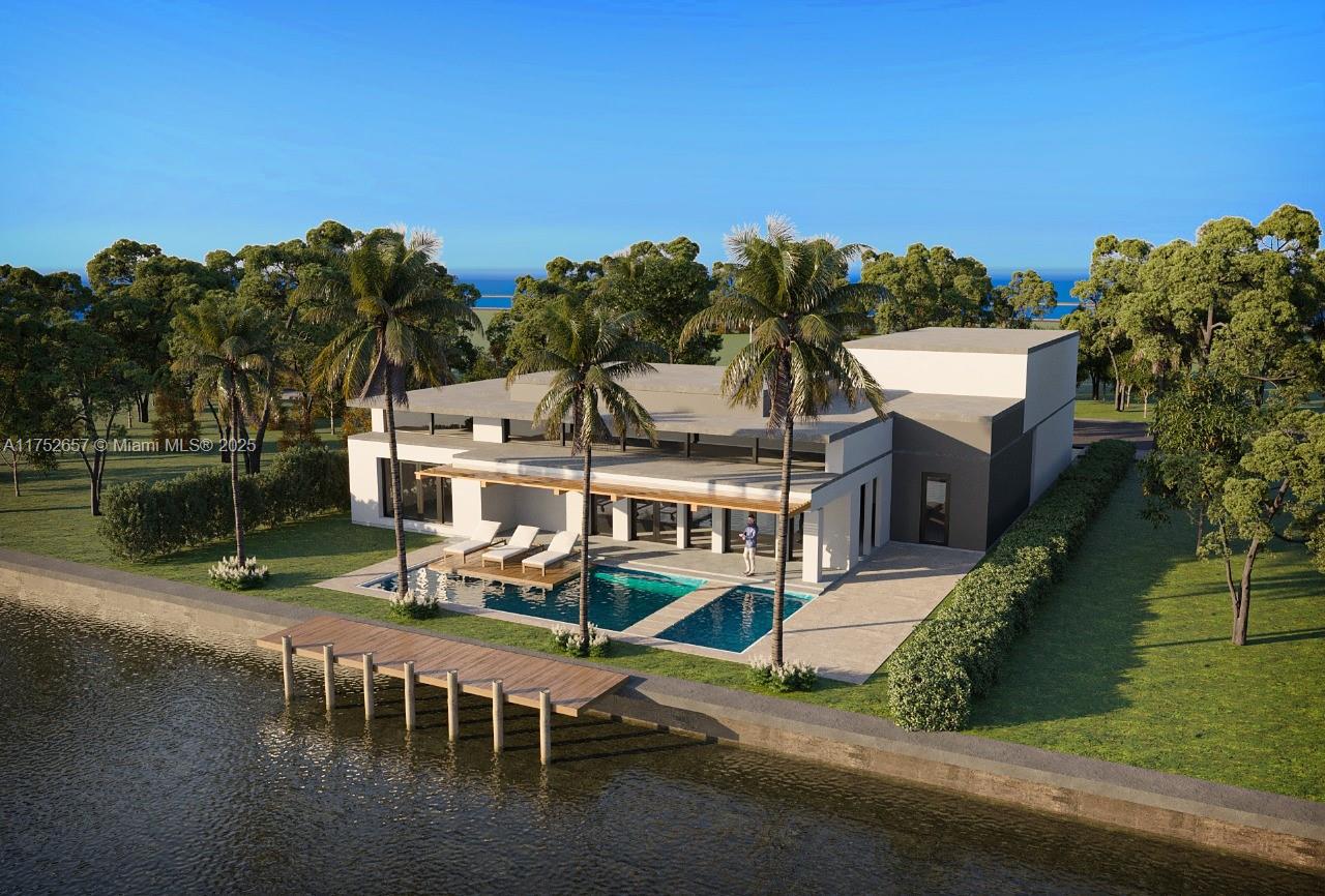 Modern waterfront home with a pool, palms and a wooden dock along the canal.