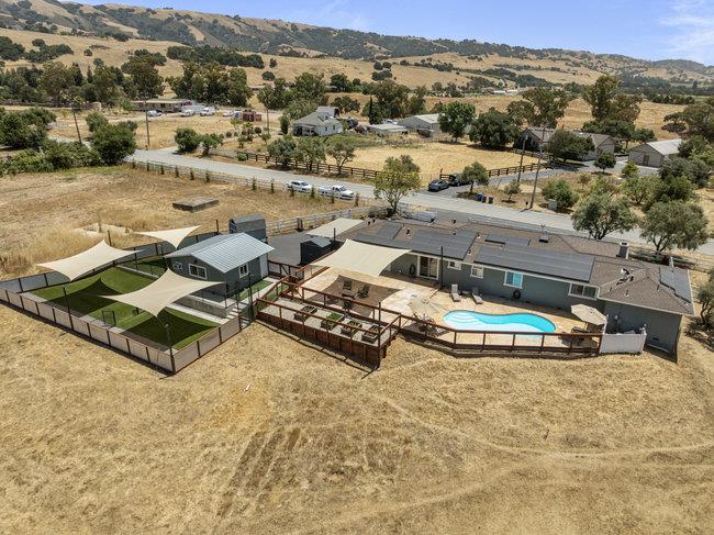 Aerial view of a rural property with a swimming pool and shade-sail-covered outdoor area.
