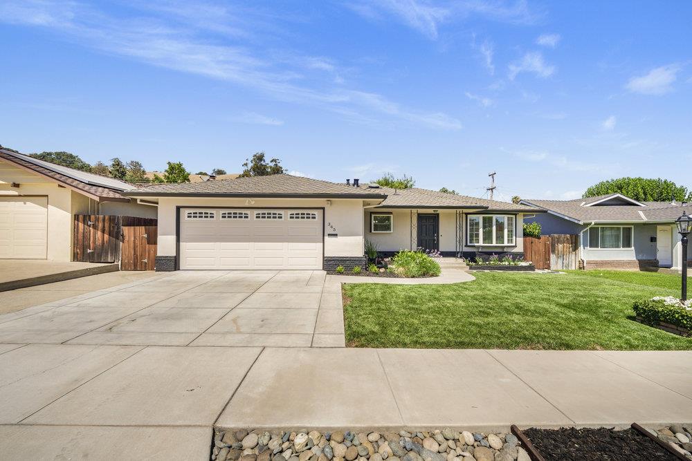 Single-story home with a two-car garage, broad driveway, and neatly landscaped front lawn.