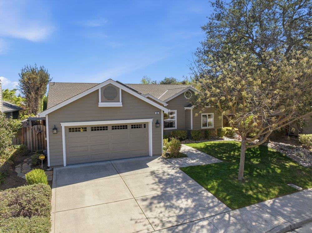 Gray single-story home with a two-car garage, broad driveway, and landscaped front yard.