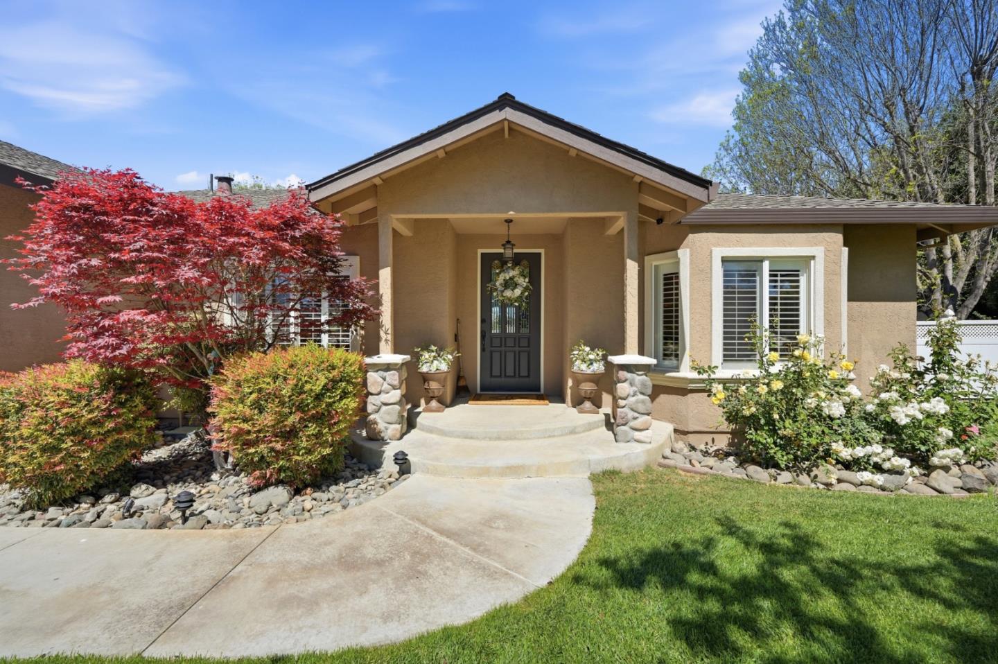 Front of 370 Union HTS, with a covered entry, curved steps, and colorful landscaping.