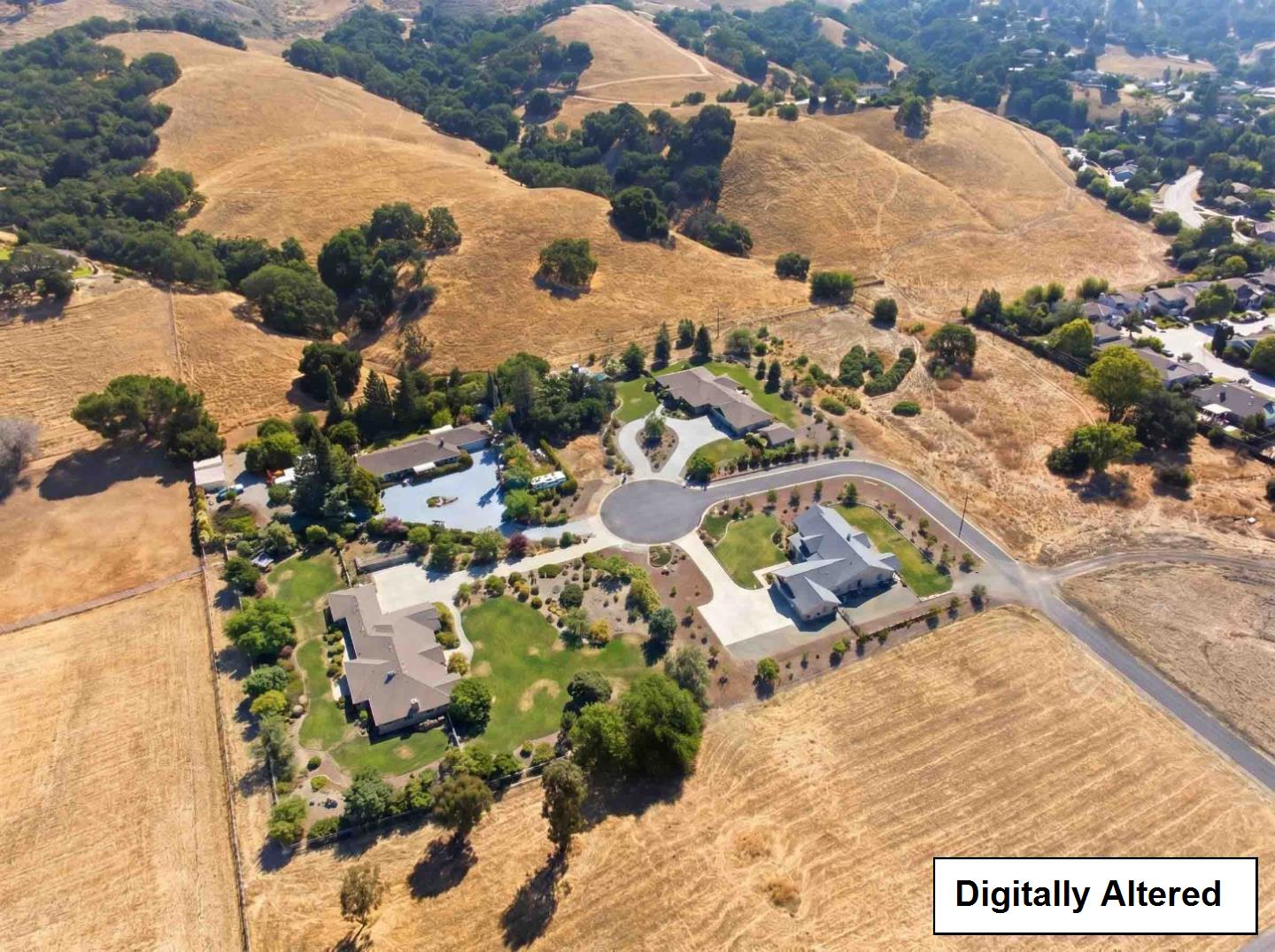 Aerial view of dry rolling hills and homes beside a residential cul-de-sac.