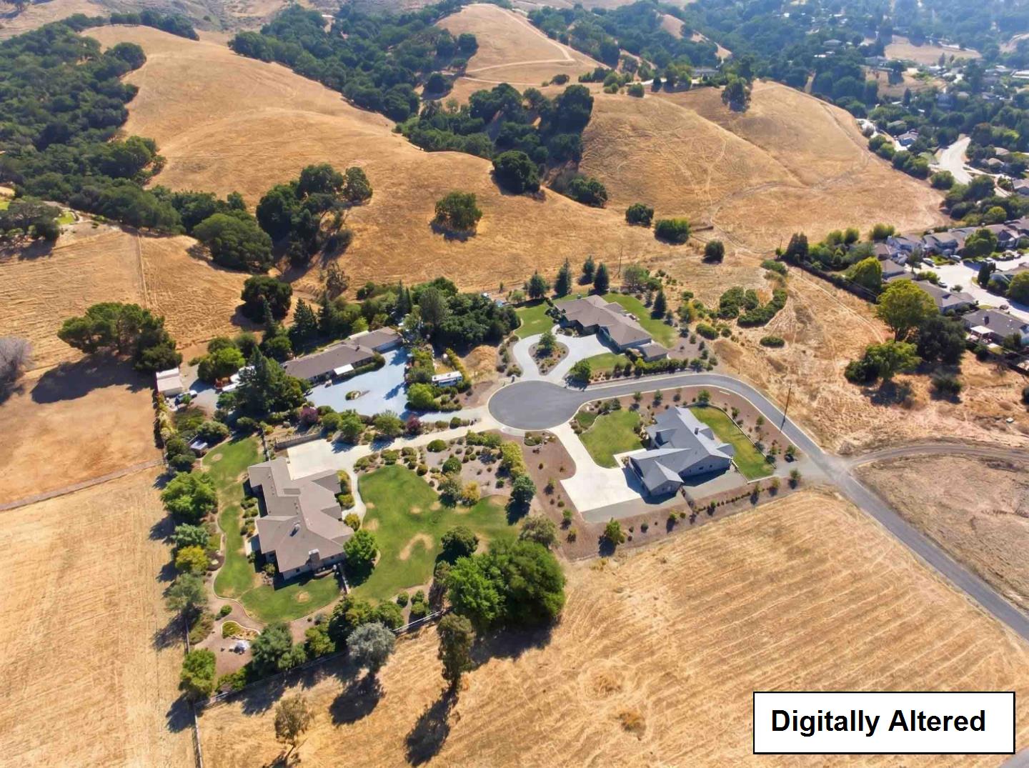 Aerial view of dry rolling acreage beside homes and a cul-de-sac in Morgan Hill.