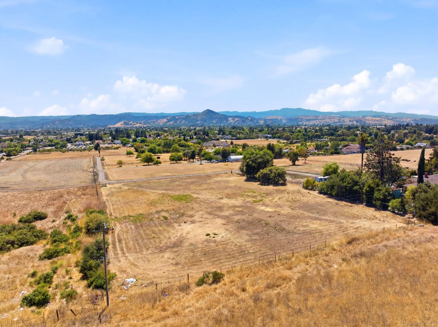 Aerial view of a vacant Morgan Hill parcel with dry open land and distant mountains.