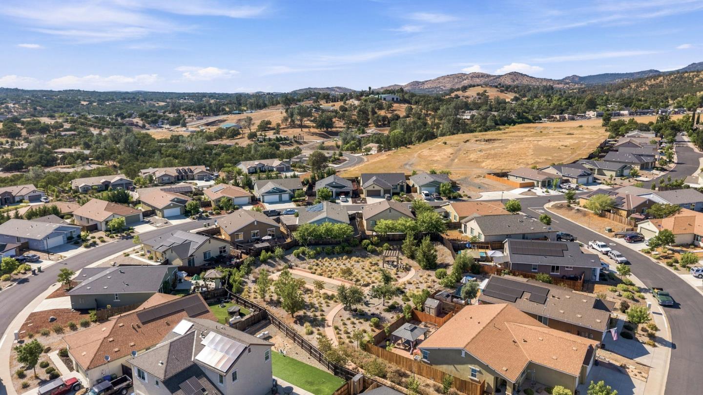 Aerial view of a residential neighborhood with rolling hills beyond.
