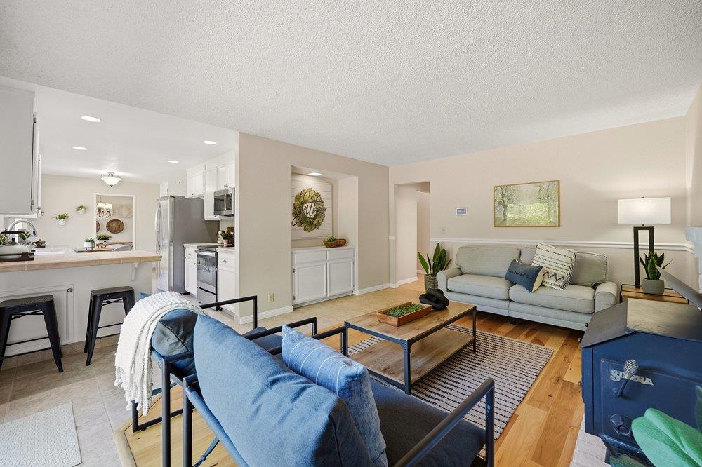 Living room with blue sofas and a coffee table beside an open kitchen and breakfast bar.
