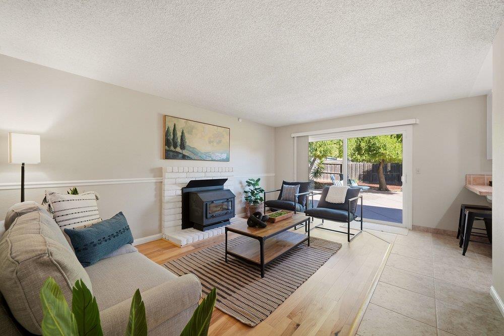Living room with a wood-burning stove, seating area, and sliding doors to a fenced patio.