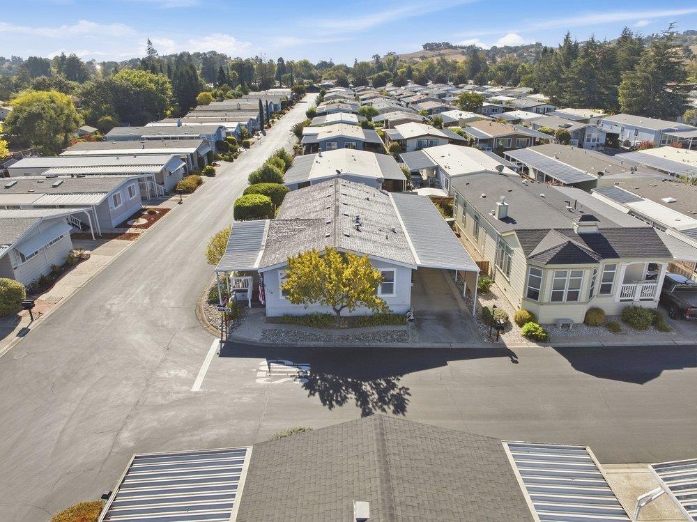 Aerial view of a manufactured-home community, with the featured home at a tree-lined corner.