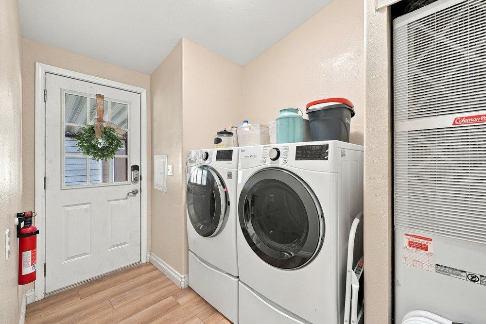 Laundry room with front-loading washer and dryer beside a glass-paneled door.
