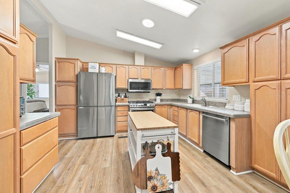 Kitchen with warm wood cabinets, stainless steel appliances, and a central island.
