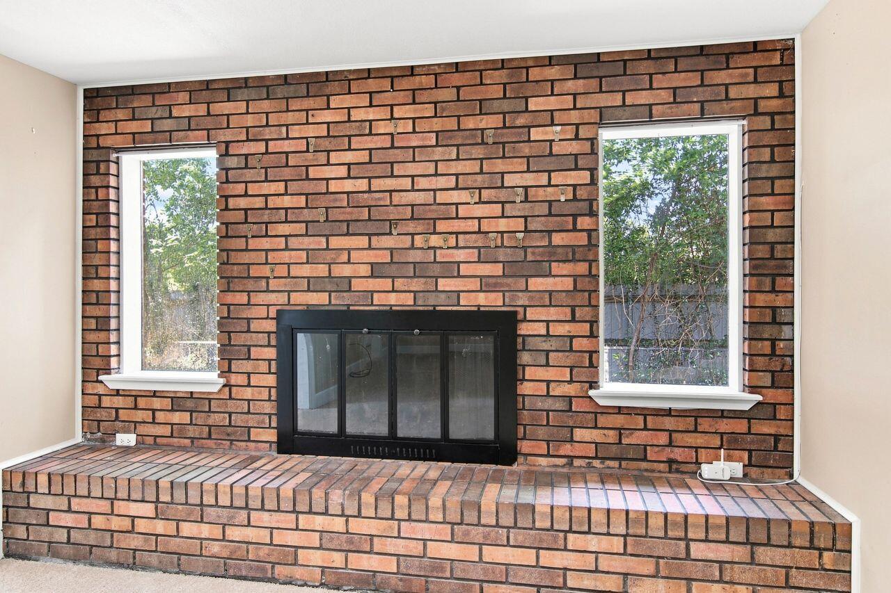 Brick fireplace with a raised hearth and windows on either side.