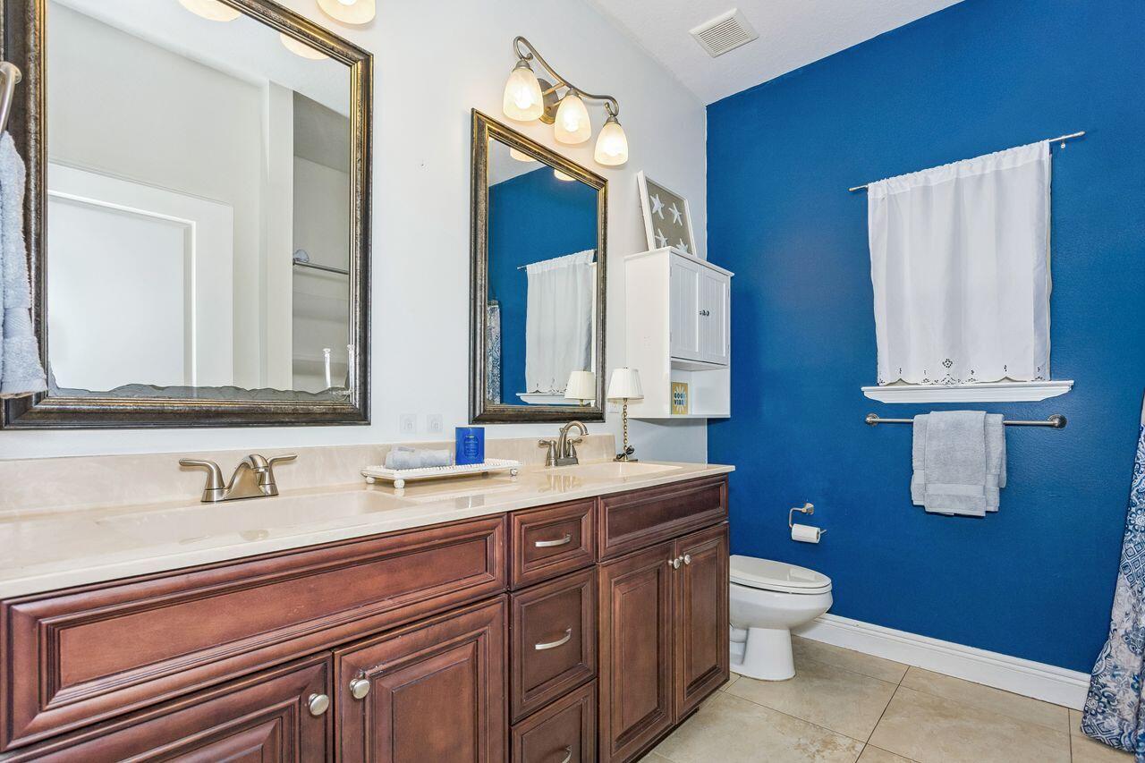 Bathroom with a dark wood double vanity and vivid blue accent wall