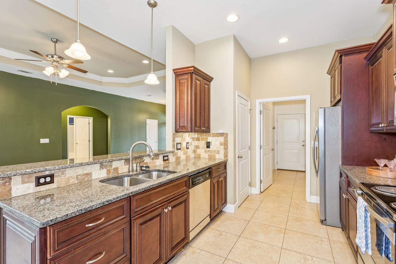 Kitchen with granite counters, dark wood cabinets, and stainless steel appliances.